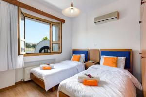 a bedroom with two beds and a window at Akamas Bay View Villa in Polis Chrysochous