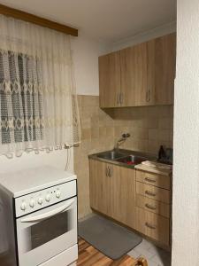 a kitchen with a white stove and a sink at Vikendica Vukovic in Foča