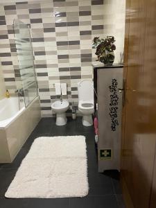 a bathroom with a toilet and a tub and a sink at Alojamento Local Afonso in Macedo de Cavaleiros +6 photos