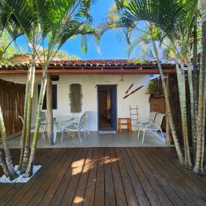 une terrasse avec des palmiers et une maison dans l'établissement Pousada Sol Nascente Caraíva, à Caraíva 49 autres photos