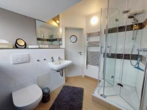 ein Badezimmer mit Toilette, Waschbecken und Dusche in der Unterkunft Backstage Apartment Kiel-Holtenau in Kiel + 22 Fotos