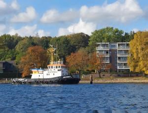 ein Boot, das in der Nähe eines Gebäudes auf dem Wasser schwimmt in der Unterkunft Backstage Apartment Kiel-Holtenau in Kiel