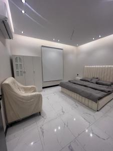 a white bedroom with a bed and a screen at Summo bilding in Jeddah