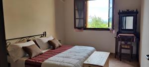 una camera da letto con un letto, una finestra e un tavolo di Agriturismo Eco-Pescaia a Montepulciano a Montepulciano