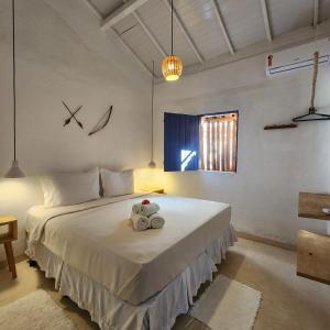 une chambre avec un lit avec un animal en peluche dessus dans l'établissement Pousada Sol Nascente Caraíva, à Caraíva