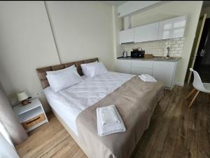 a bedroom with a large bed and a kitchen at Luxury Studio See view-Batumi New Boulevard -white S 1412 in Batumi