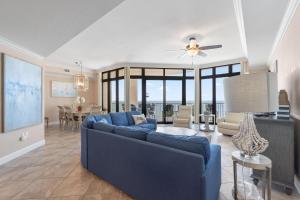 a living room with a blue couch and a dining room at The Oasis at Orange Beach 609 (Phoenix West II) in Orange Beach