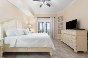a bedroom with a white bed and a television at The Oasis at Orange Beach 609 (Phoenix West II) in Orange Beach +111 photos