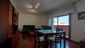 a living room with a table and chairs and a couch at O Xardín Termal in Ourense +8 photos