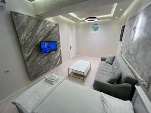 Una sala de estar con un sofá y un televisor. en Formula 1-BAKU CITY, en Baku