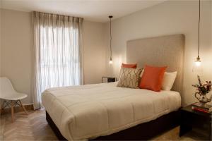 a bedroom with a large bed with orange pillows at Casa Nduxi Puebla Departamentos in Puebla +116 photos