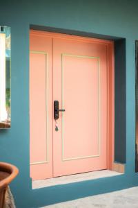 a pink door in the corner of a room at Casa Nduxi Puebla Departamentos in Puebla