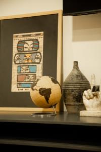 a shelf with vases and a globe on a table at Casa Nduxi Puebla Departamentos in Puebla