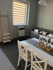 a living room with a table and a couch at Apartman - Garden - Vendégház 2 in Nesvady