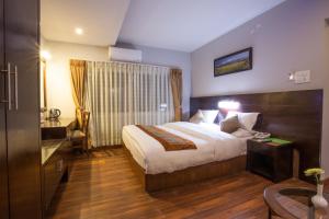 una camera d'albergo con un letto e una scrivania di Aryatara Kathmandu Hotel a Kathmandu