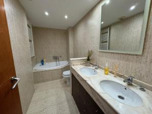 a bathroom with two sinks and a toilet and a mirror at Costapera in La Pobla de Segur +5 photos