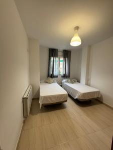 a room with two beds and a window at Costapera in La Pobla de Segur
