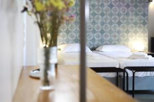 a room with two beds and a vase of flowers on a table at Just Barrett in Rovies