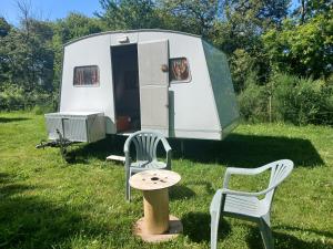 a white trailer with a table and two chairs at Caravane vintage in Pornichet