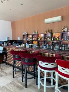 a bar with red stools in a restaurant at Seaside View Apartment in Varna in Varna City