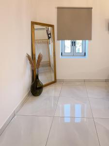 a room with a mirror and a vase on a tile floor at Thetis, the Beach House in Nafplio +59 photos