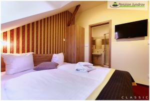 1 cama con sábanas blancas y almohadas en una habitación en Penzion Vanessa, en Brno