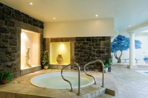 y baño grande con bañera en una pared de piedra. en Tre-Ysgawen Hall & Spa, en Llangefni