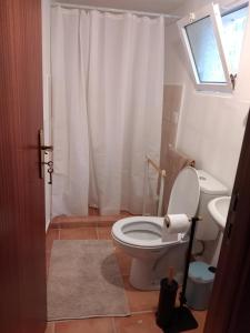 ein Badezimmer mit weißer Toilette und Waschbecken in der Unterkunft Casa Gama in Ribeira da Janela