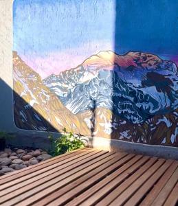 un murale di una montagna su un muro con una panchina di The south face house 2Pax - By Inside a La Cieneguita