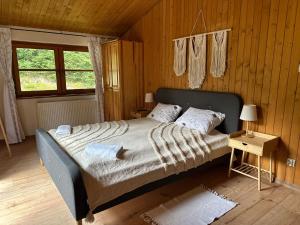 a bedroom with a large bed in a wooden room at Cicha Woda in Pieszyce