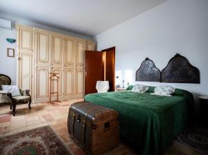 a bedroom with a green bed and a suitcase at La finestra sul limone in Castelvetrano Selinunte