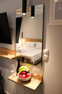 Una habitación con una cama y un bol de fruta y copas de vino. en Diamond Light Apartments, en Nikiti