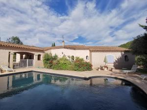 a swimming pool in front of a house at Le Loriot in Auriol