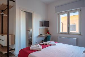 a bedroom with a bed with two towels on it at Le Stagioni di Heraclea in Policoro +28 photos