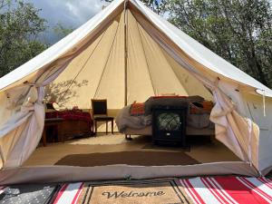 a tent with a bed and a stove in it at #Y5 Lumberjack Lounge Yurt in Drumheller