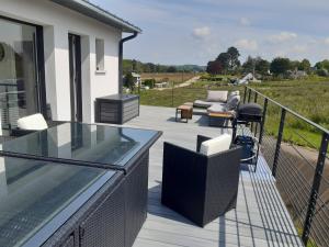 a balcony with a glass table and chairs on it at Maison FlaCeLo in Locquirec