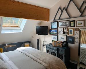 a bedroom with a bed and a tv on a wall at Ambleside Lodge Bed & Breakfast in Canmore