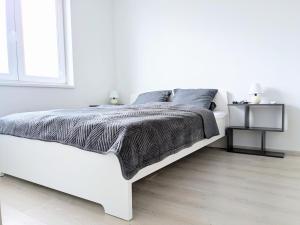 a white bedroom with a white bed and a window at Apartman Amanda - Ohrada in Choťánky