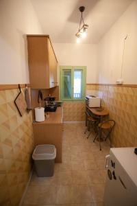 a small kitchen with a toilet and a table at Morning Glory Apartment in Paralia Katerinis