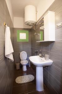 a bathroom with a sink and a toilet and a mirror at Morning Glory Apartment in Paralia Katerinis +23 photos