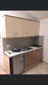 une cuisine avec des armoires blanches et un évier dans l'établissement Vila Balliu, à Buçimas