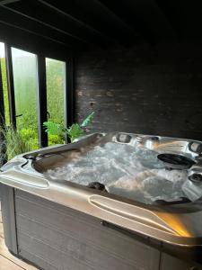 a hot tub in a room with a window at La cabane de Lulu in Jalhay