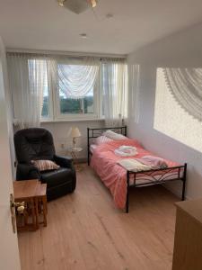 a bedroom with a bed and a chair and a window at Zentrales Apartment für bis zu 5 Personen mit Balkon, Parkplatz, Waschmaschine & direkten Einkaufsmöglichkeiten in Marl