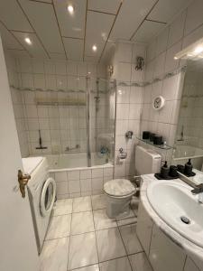 a bathroom with a toilet and a shower and a sink at Zentrales Apartment für bis zu 5 Personen mit Balkon, Parkplatz, Waschmaschine & direkten Einkaufsmöglichkeiten in Marl +5 photos