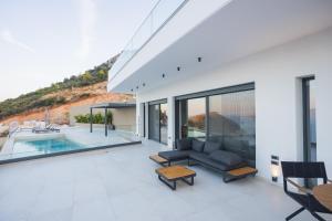 a living room with a couch and a pool at Panoramic Villa in Tolo
