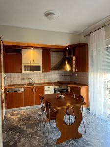 アレクサンドルポリスにあるMargi Homeの木製のテーブルとテーブルと椅子のあるキッチン