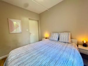 a bedroom with a large bed with blue comforter at Pétillant T2 rez-de-jardin in Bonneville