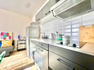 a kitchen with a refrigerator and a counter top at Pétillant T2 rez-de-jardin in Bonneville +2 photos