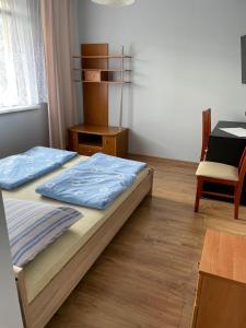 什恰夫尼察Szczawnica - Pokoje z widokiem na góry的一间卧室，有两张床、一张桌子和一张椅子