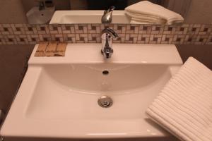 La salle de bains est pourvue d'un lavabo blanc et d'un robinet. dans l'établissement Vico Gabella B&B, à Castellana Grotte